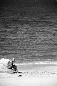 Man sitting on shore at beach