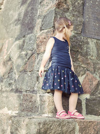 Full length of girl standing on retaining wall