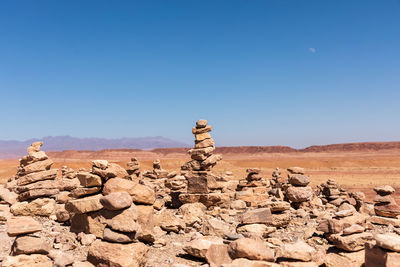 View of rock signature figurine on landscape against clear blue sky