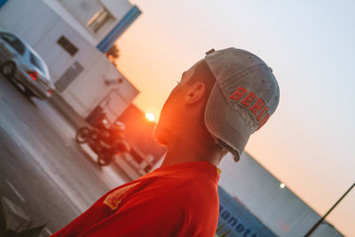 Portrait of man wearing hat against sky at sunset
