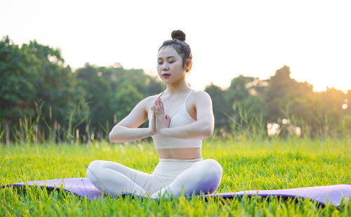 Portrait of young woman sitting on grassy field