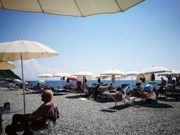 People on beach against clear sky