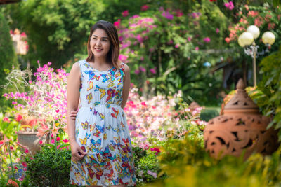 Young woman standing by flowering plants