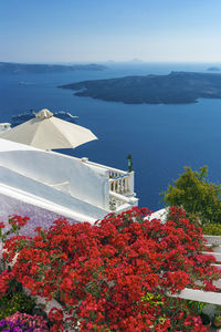 Scenic view of sea by mountain against sky