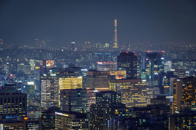 Illuminated cityscape against sky at night