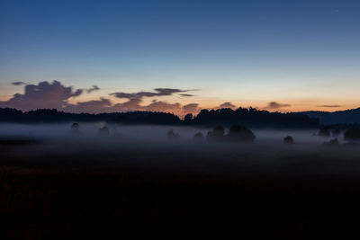 Misty landscape against blue sky