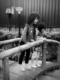 Full length of woman sitting on railing