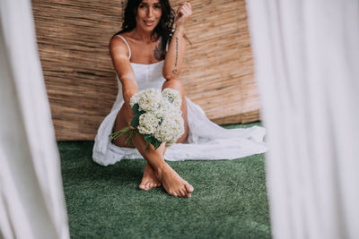 Full length of woman holding white flowers