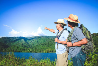 People standing on mountain against sky