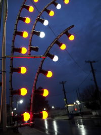 Low angle view of illuminated street lights at night