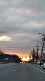 Cars on road against sky at sunset