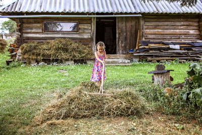 Woman standing in front of wooden house