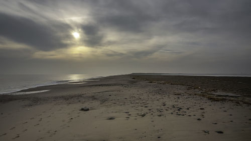 Scenic view of beach against sky during sunset