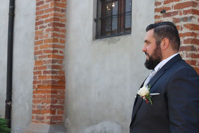 Man standing against brick wall