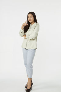 Portrait of a smiling young woman against white background