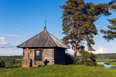  wooden chapel and stone cross on the top of savkin hill, pushkinskiye gory reserve, russia 