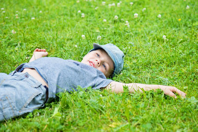 Portrait of boy lying on grassy field