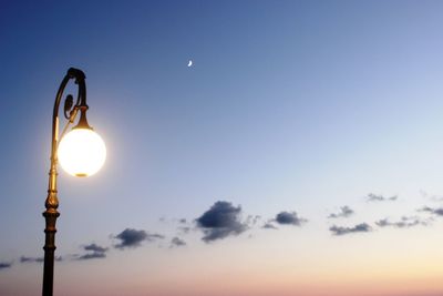 Low angle view of illuminated street light against sky