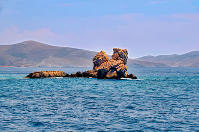 Rock formation in sea against sky