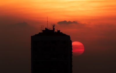 Silhouette of building against cloudy sky during sunset