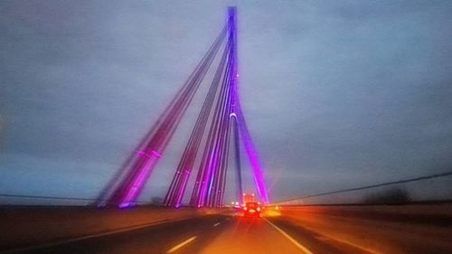 Road passing through illuminated tunnel