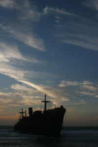 Silhouette ship on sea against sky during sunset