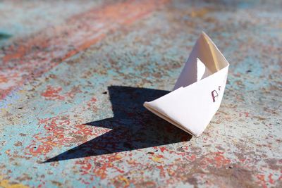Close-up of paper boat on rusty table