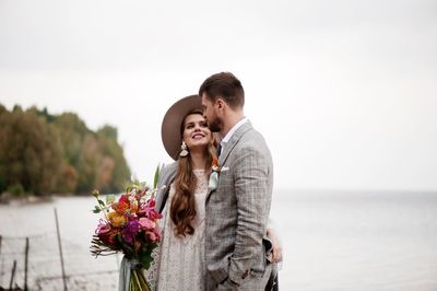 Bride and bridegroom standing at beach during wedding ceremony