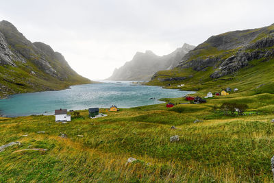 Scenic view of hiking trail leading to houses in village vinstad at the coast in lofoten norway