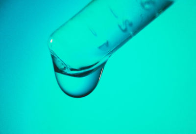 Close-up of drinking water against blue background