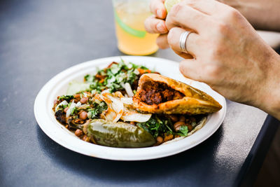 Cropped hand of person having mexican food at restaurant