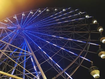 Low angle view of illuminated ferris wheel against sky