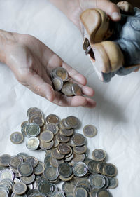 High angle view of hand holding coins