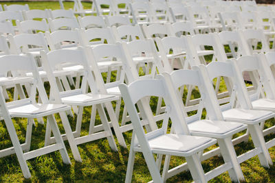 Multiple white folding chairs for event. outdoor city wedding.