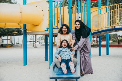 Mother with cheerful daughters enjoying at park