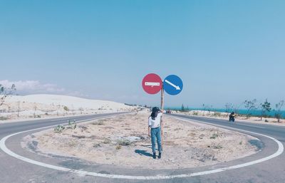 Road sign against clear blue sky