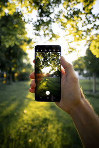 Human hand holding smart phone outdoors