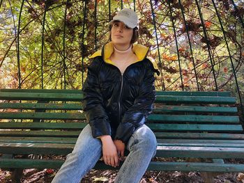 Portrait of young woman sitting on bench