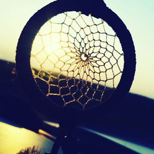 Close-up of silhouette wheel against sky