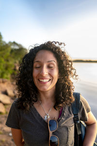 Portrait of young woman standing against sky