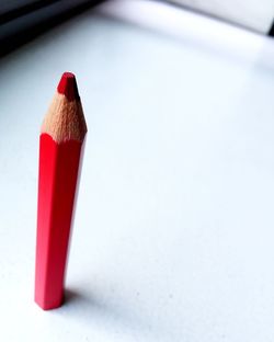 Close-up of red pencil on table