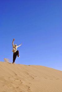 Man standing in desert against sky