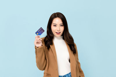 Young woman smiling against blue background