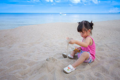 Girl playing on beach against sea