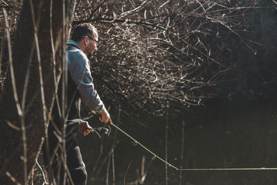 Man fishing in lake at forest