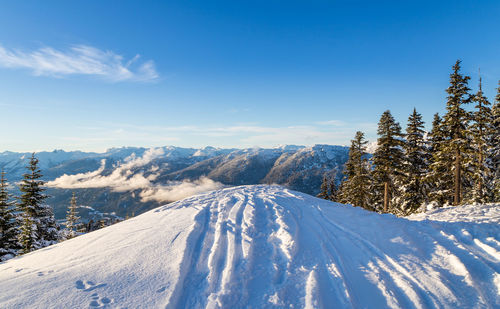 Scenic view of snowcapped mountains against blue sky