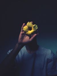 Close-up of man holding fruit over white background