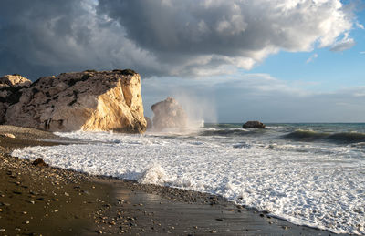 Scenic view of rocks on beach against sky