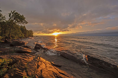 Sunset, waves and rocks on lake superior in porcupine mountains state park in michigan