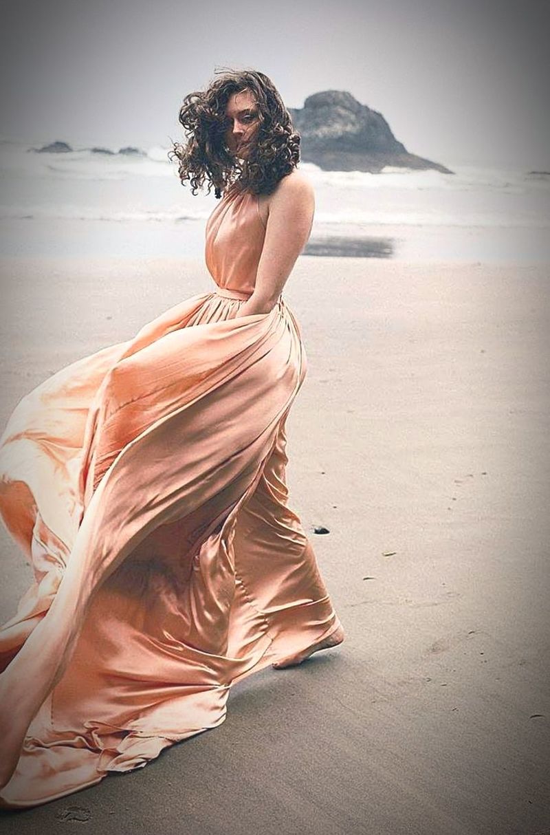 WOMAN SITTING AT BEACH